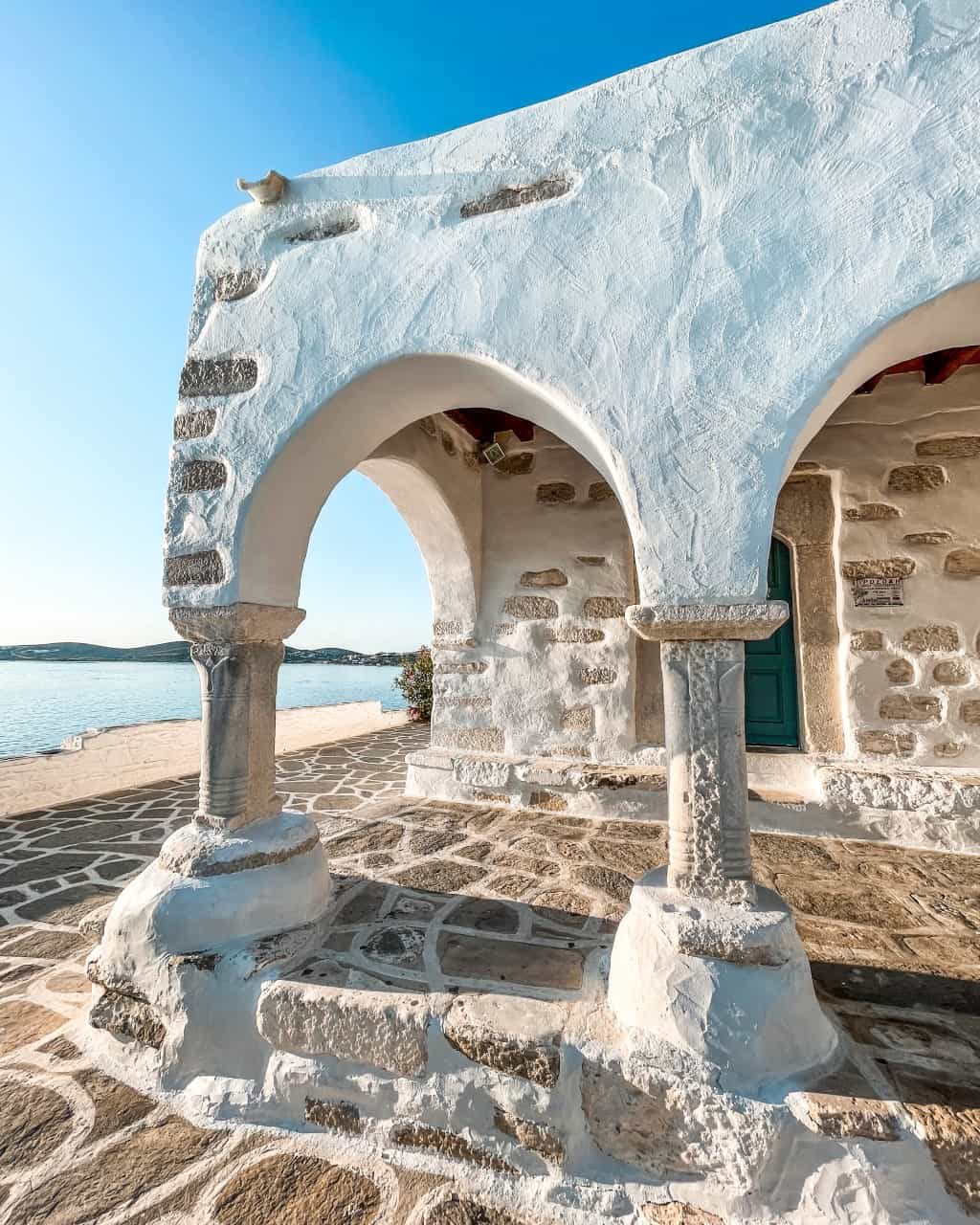 An old, white building with beautiful columns and arches showcasing the Venetian archtitecture in Parikia, Paros.