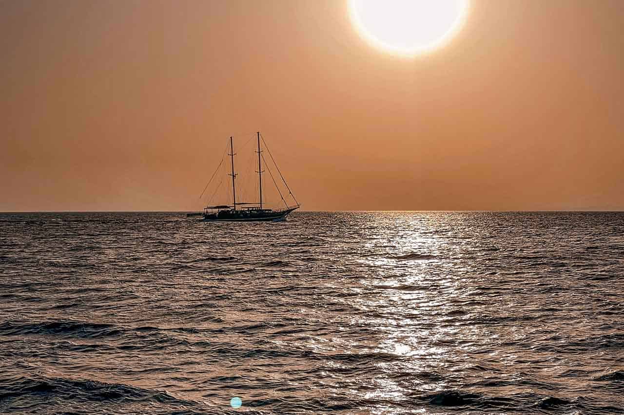 Wooden ship sailing into the sunset