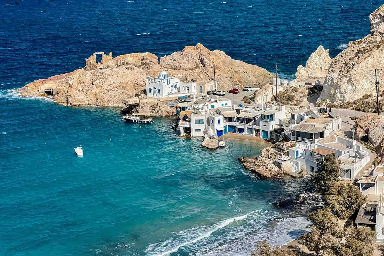 A whitewashed fishing village in Milos perched on cliffs overlooking the sea