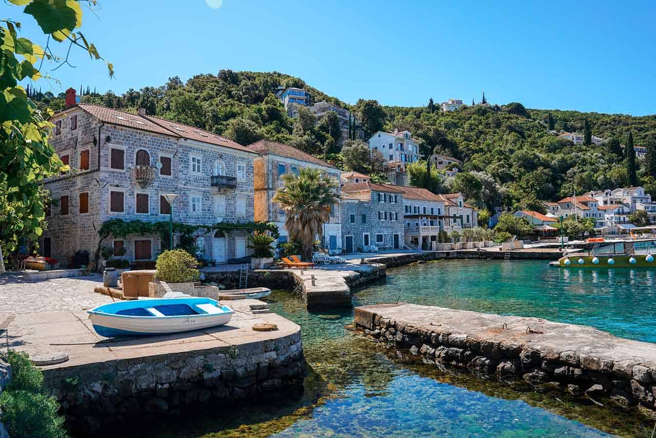 View of the picturesque waterfront of Rose village, with old stone houses and a small marina